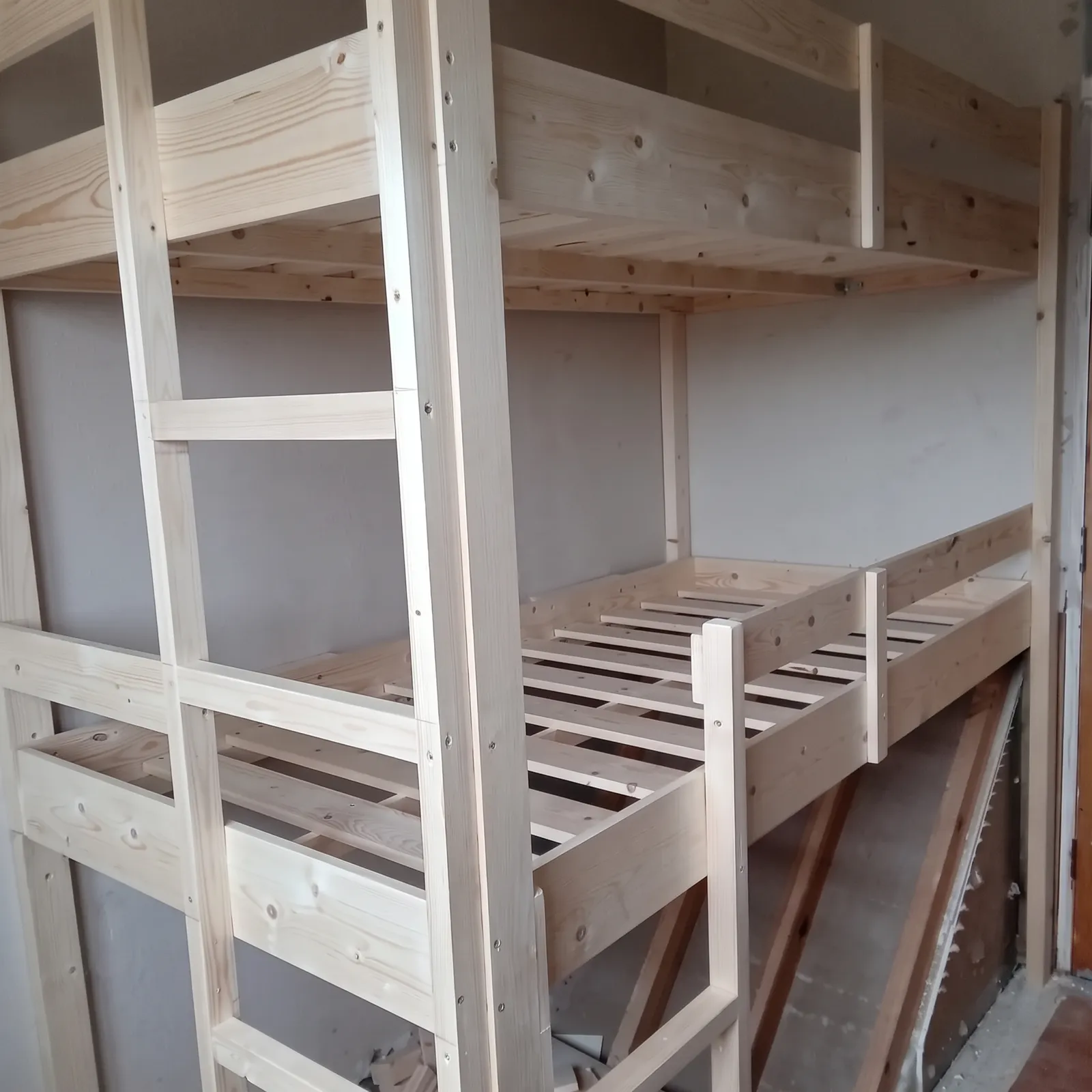 Bespoke timber bunk beds with ladder, built into a bedroom before painting